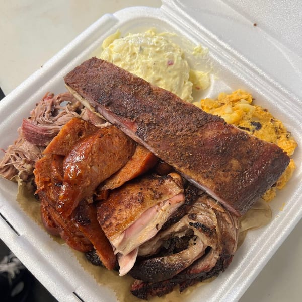 Rack City Ribz BBQ platter with ribs, pulled pork, sausage, chicken, potato salad, and mac and cheese.